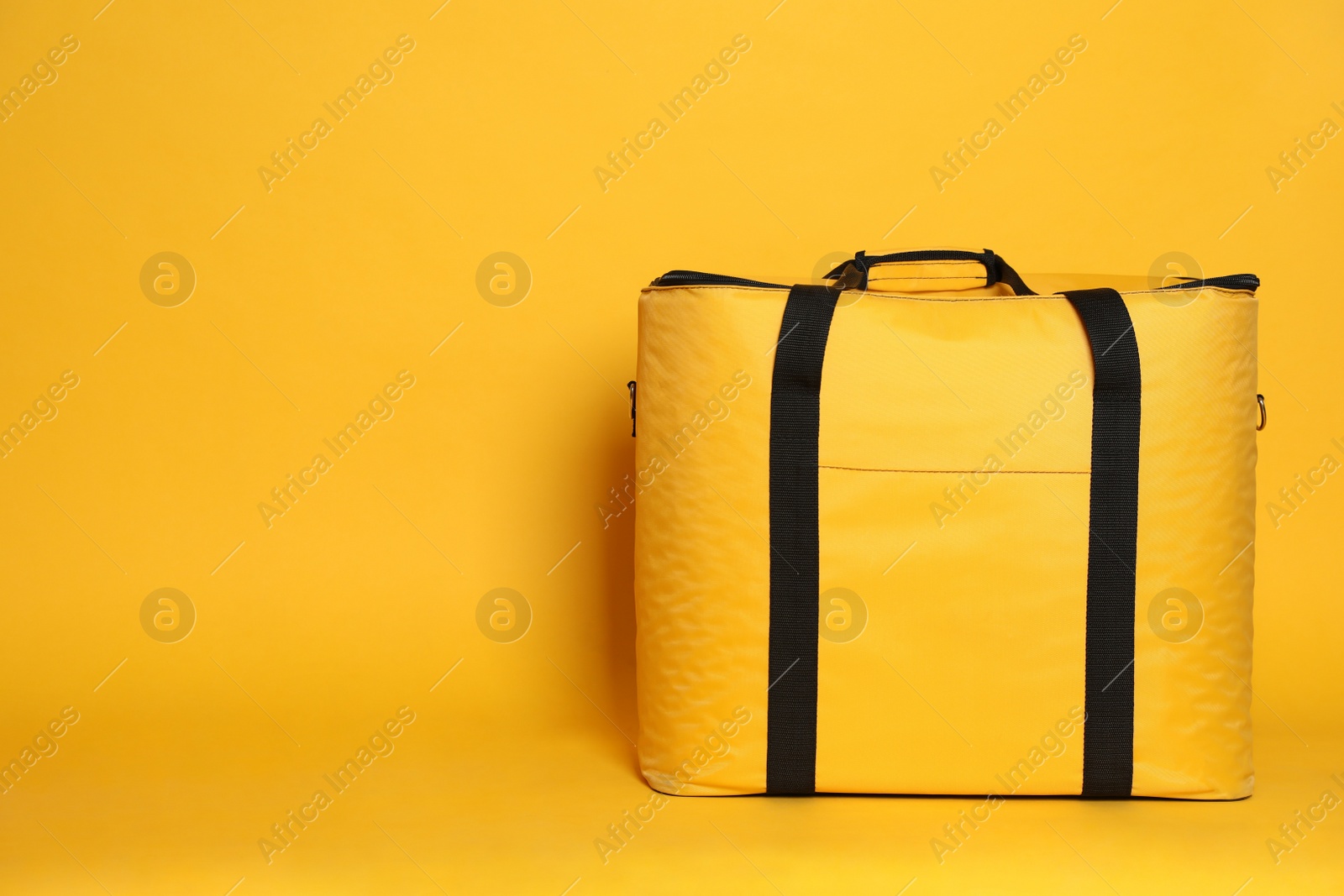 Photo of Modern thermo bag on yellow background. Space for text