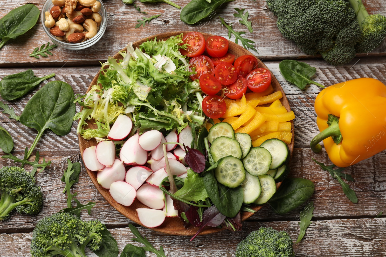 Photo of Vegetarian diet. Plate with tasty vegetables on wooden table, flat lay