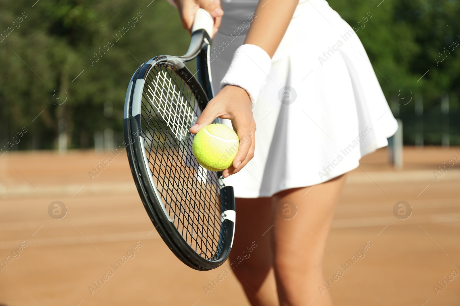 Photo of Sportswoman preparing to serve tennis ball at court, closeup