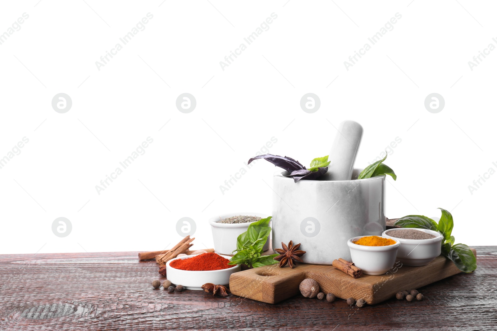 Photo of Mortar and different spices on wooden table against white background. Space for text