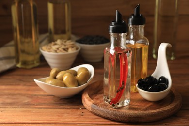 Photo of Different cooking oils and ingredients on wooden table