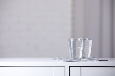 Glasses with pure water on white table indoors, space for text