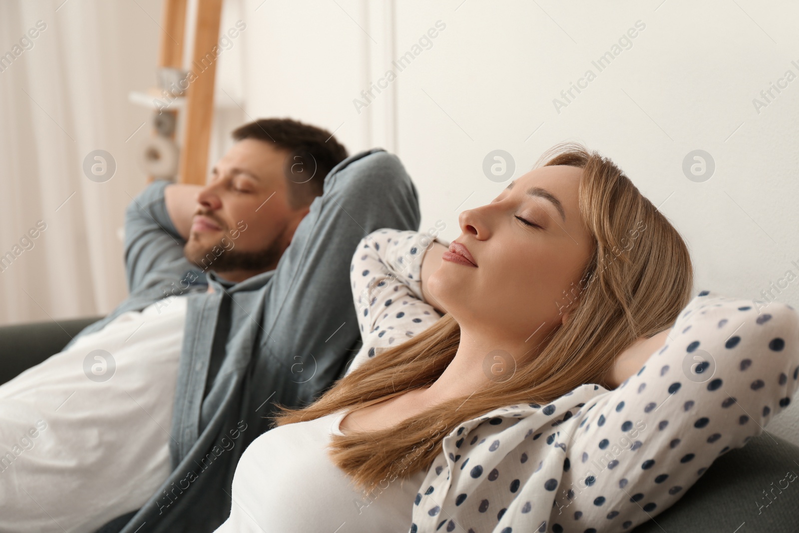 Photo of Couple relaxing on sofa in living room