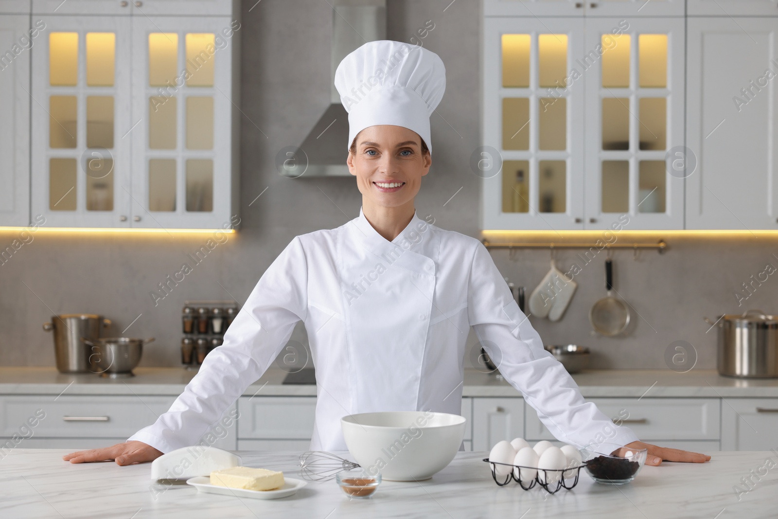 Photo of Portrait of professional chef near table with ingredients in kitchen