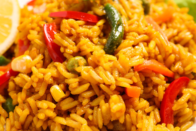 Photo of Delicious rice pilaf with vegetables as background, closeup