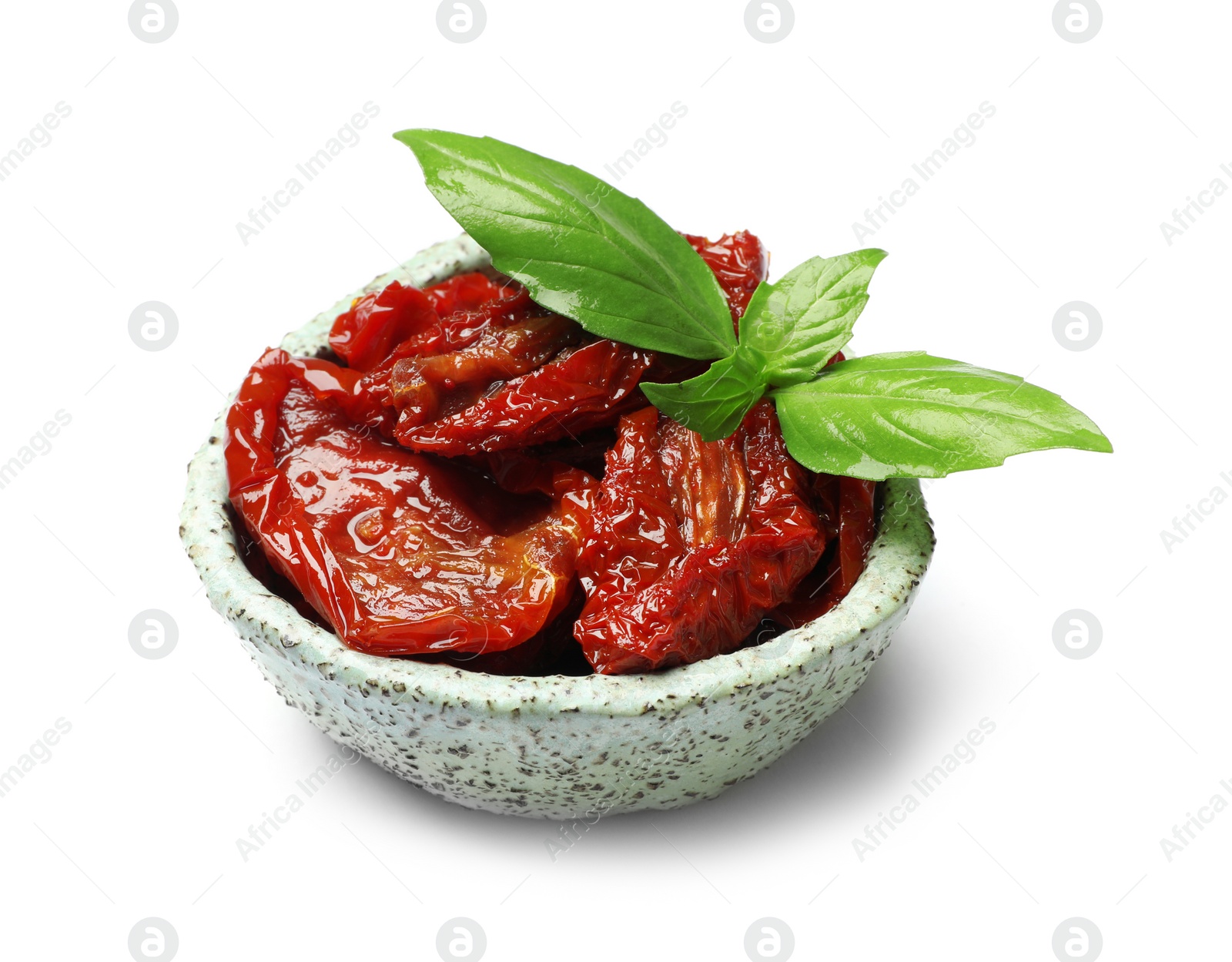 Photo of Bowl with sun dried tomatoes and green leaves on white background