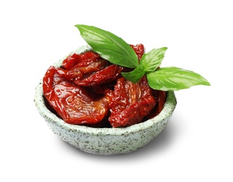 Bowl with sun dried tomatoes and green leaves on white background