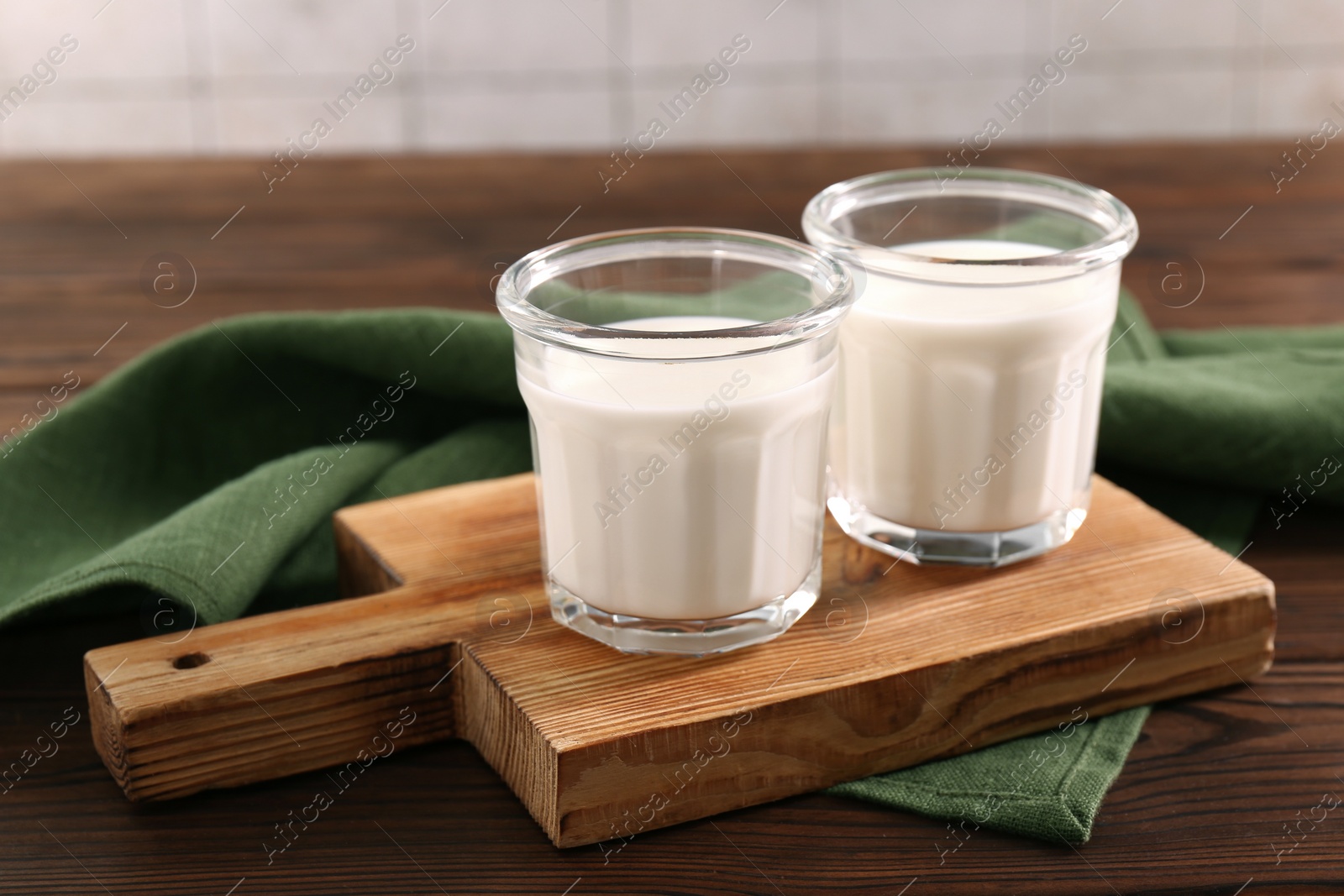 Photo of Glasses of tasty milk on wooden table, space for text