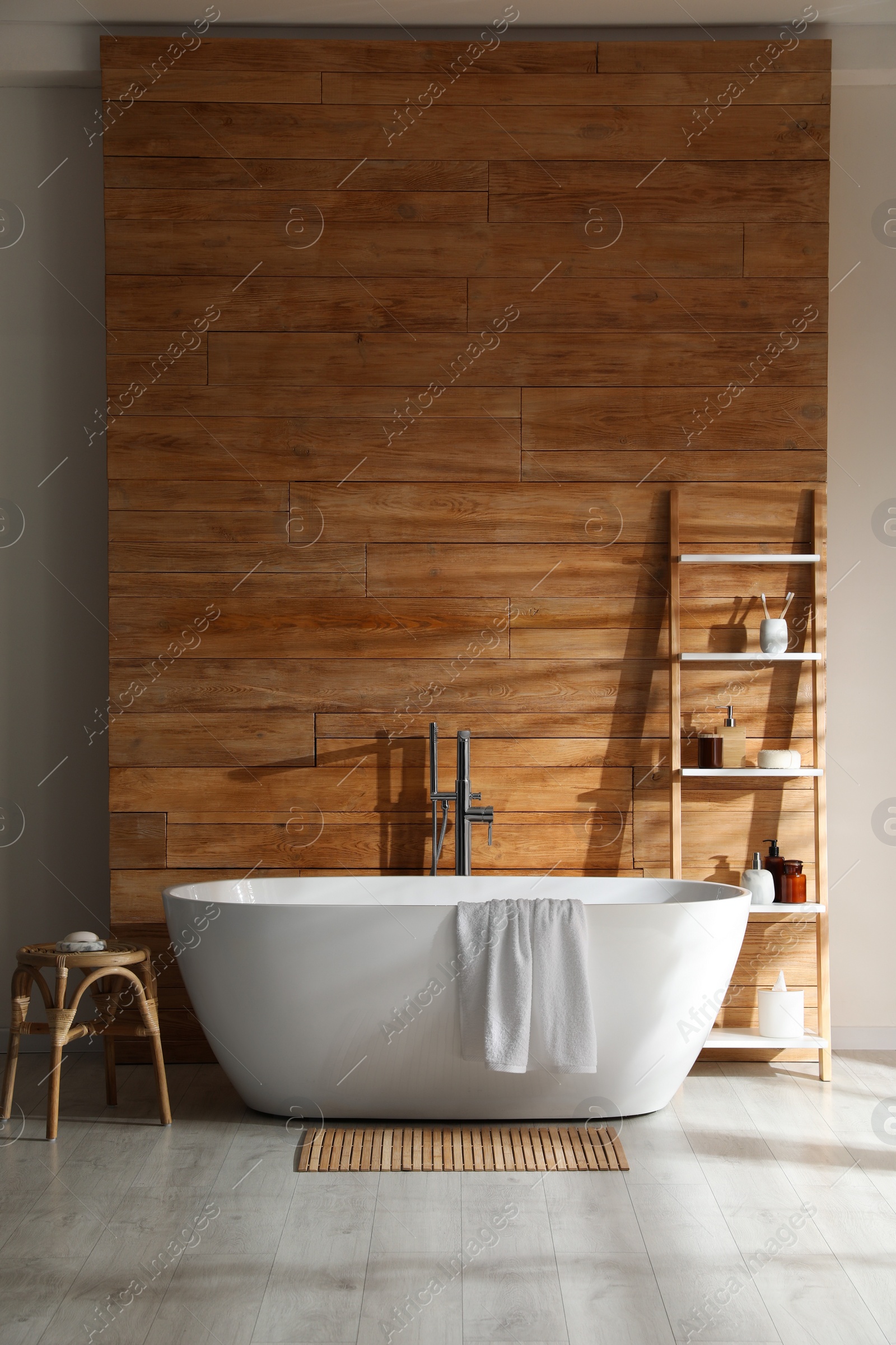 Photo of Bathroom interior with white tub and decor near wooden wall