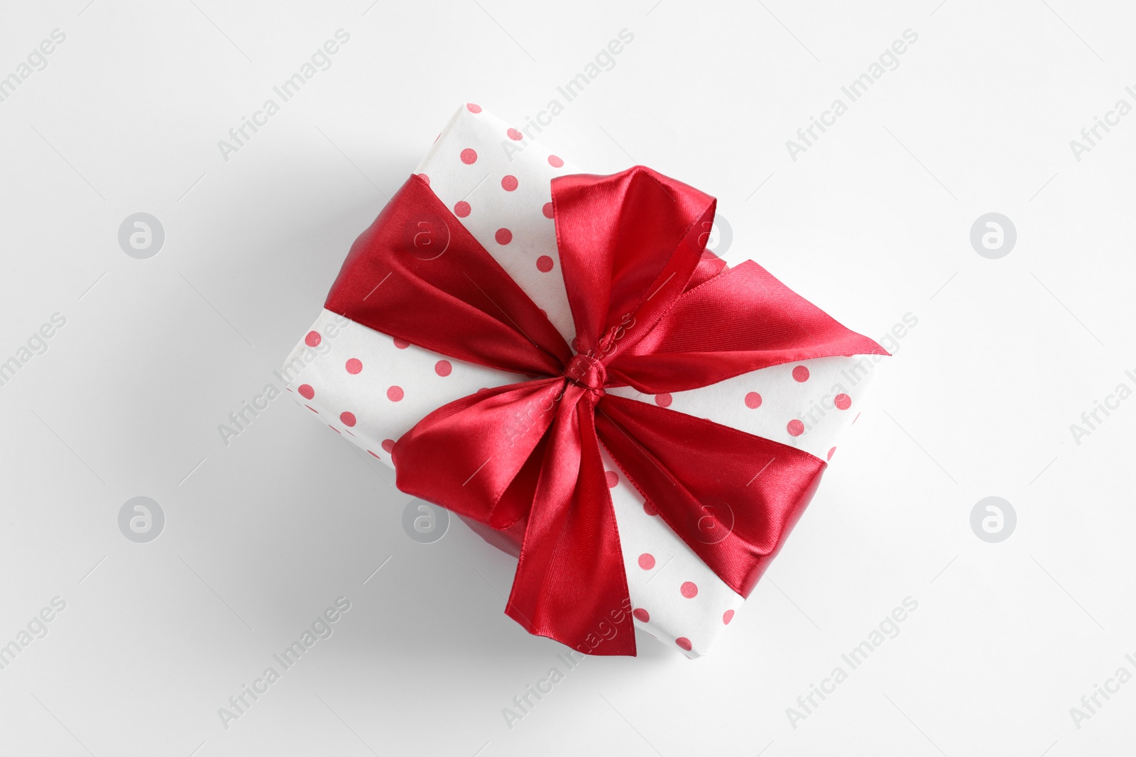 Photo of Beautifully wrapped gift box on white background, top view