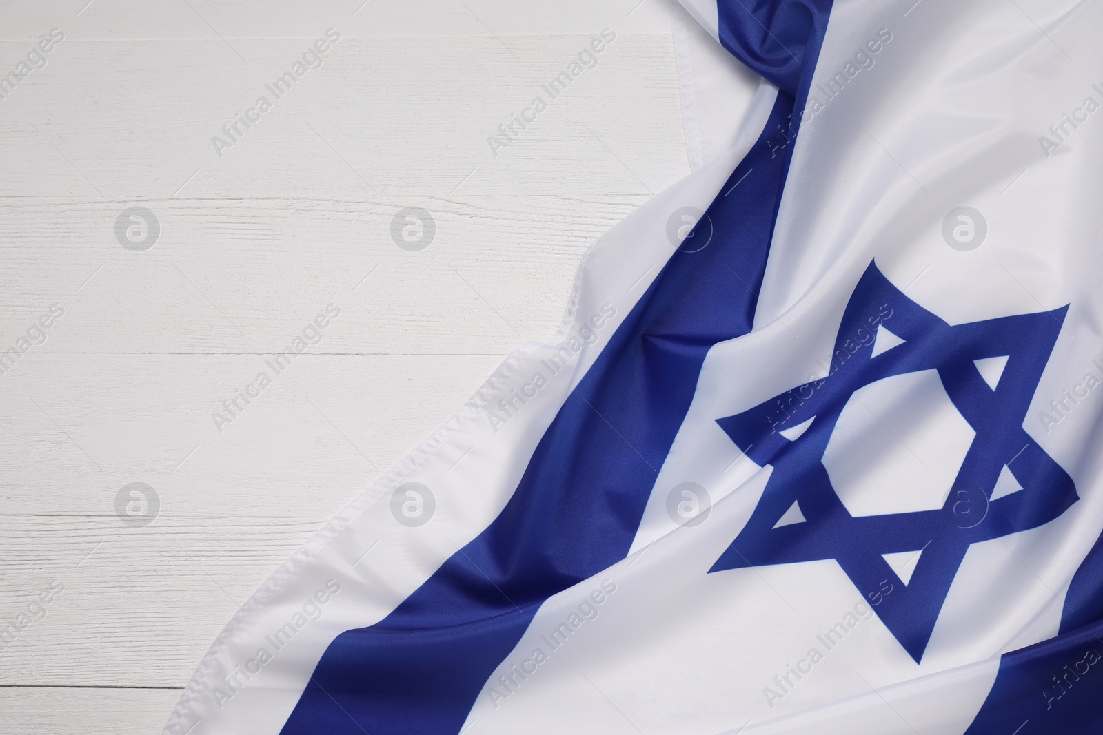 Photo of Flag of Israel on white wooden background, top view and space for text. National symbol