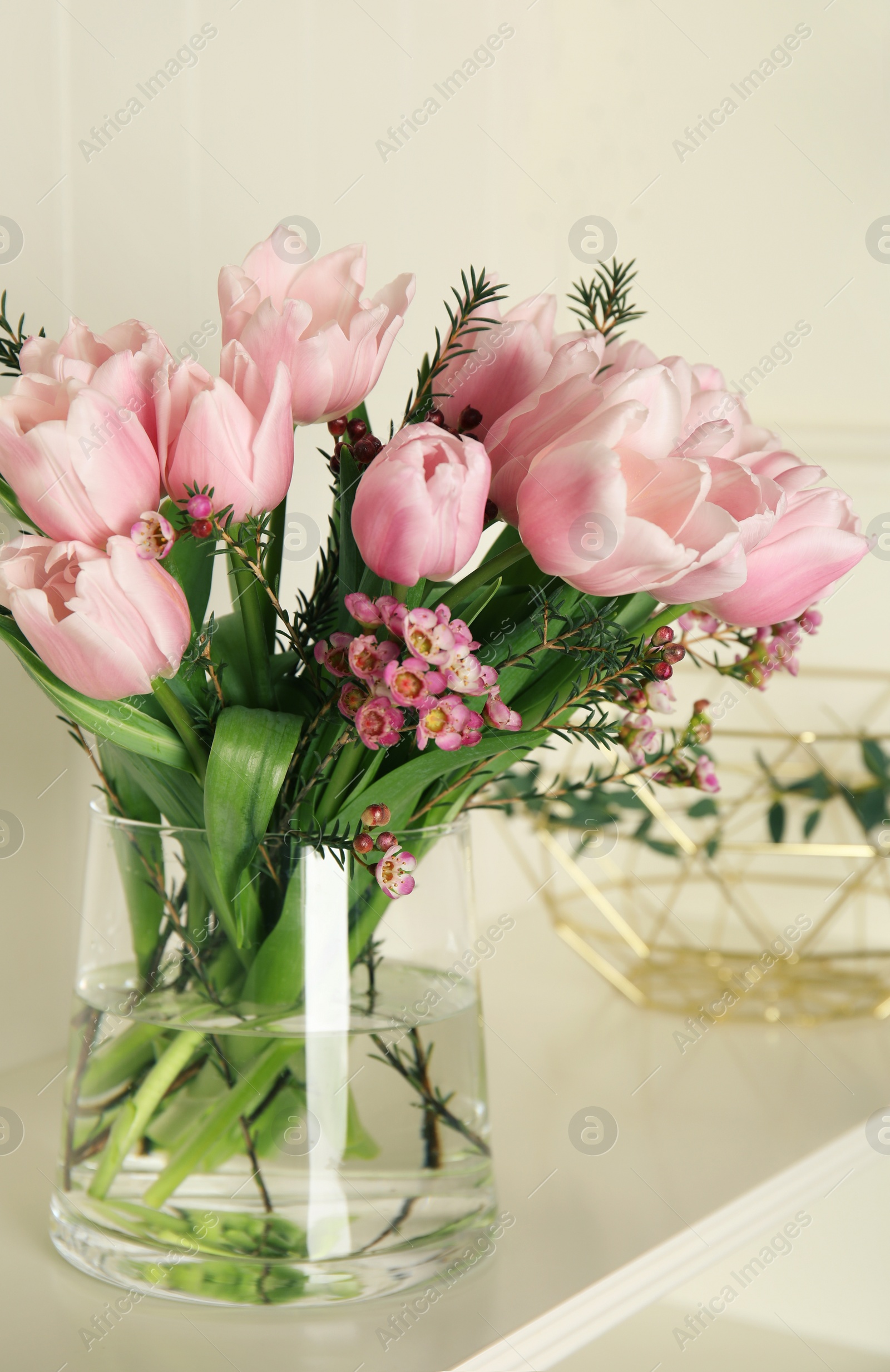 Photo of Beautiful bouquet with spring pink tulips on shelf