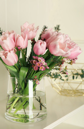 Photo of Beautiful bouquet with spring pink tulips on shelf