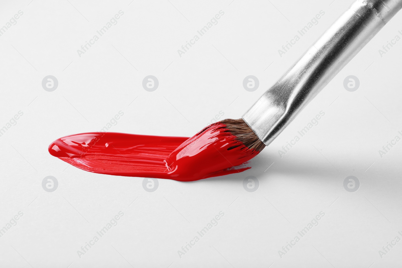 Photo of Brush with color paint and stroke on white background