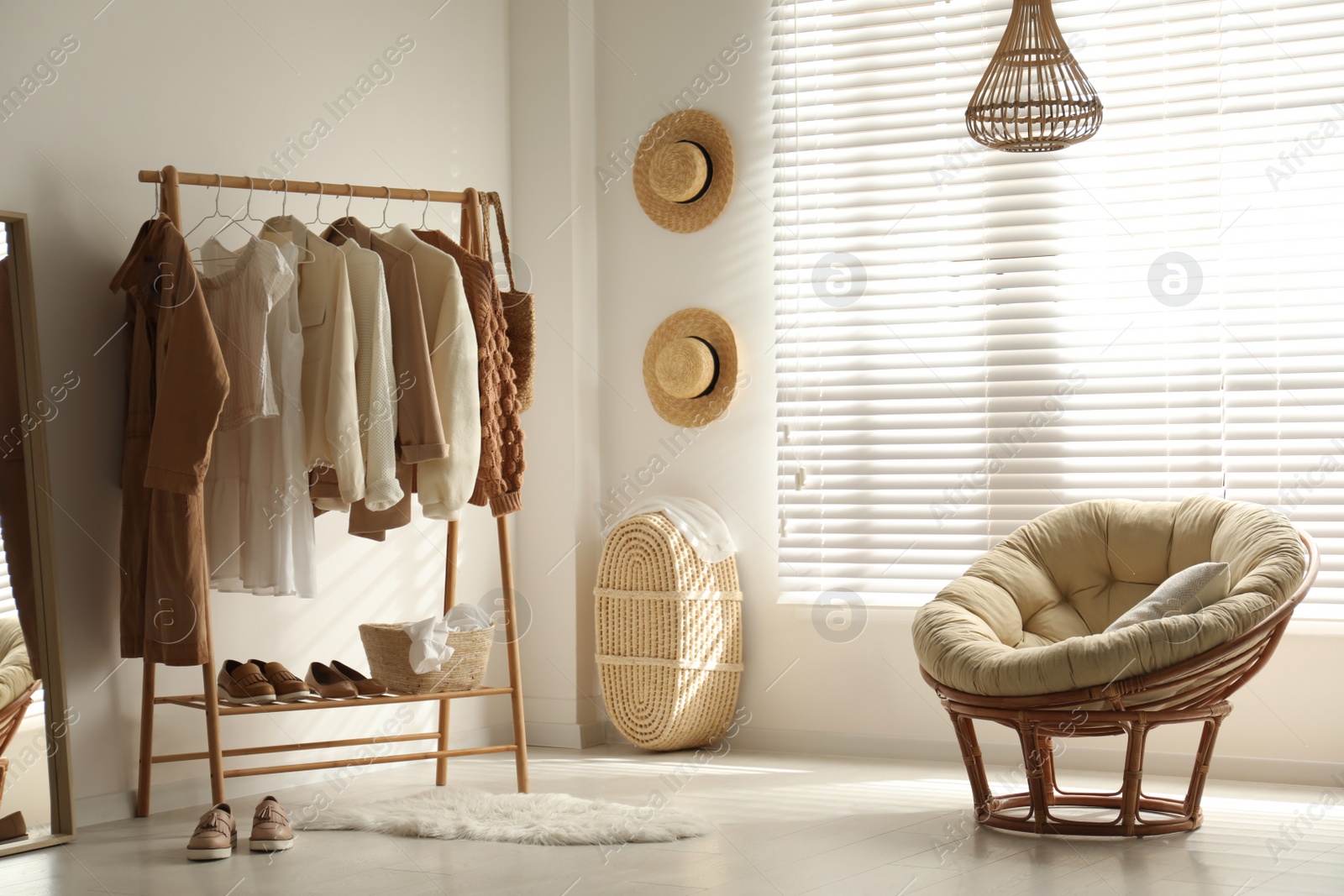 Photo of Modern dressing room interior with rack of stylish women's clothes