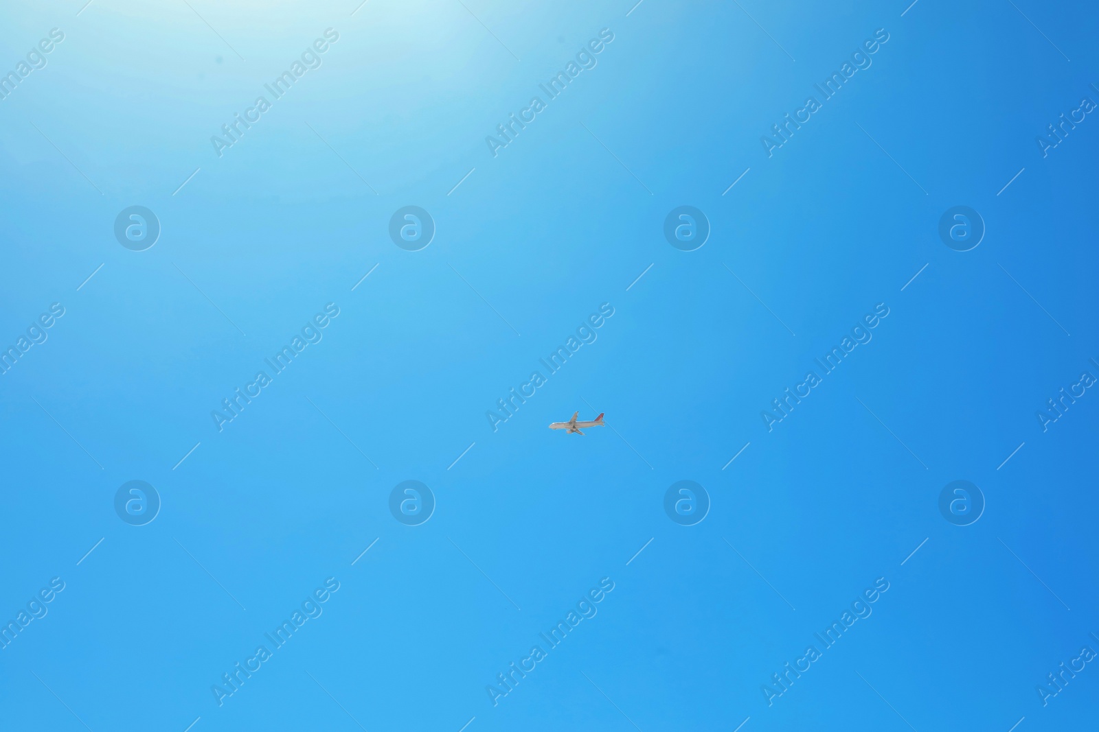 Photo of Distant view of modern airplane in blue sky