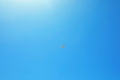 Distant view of modern airplane in blue sky