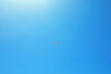 Photo of Distant view of modern airplane in blue sky