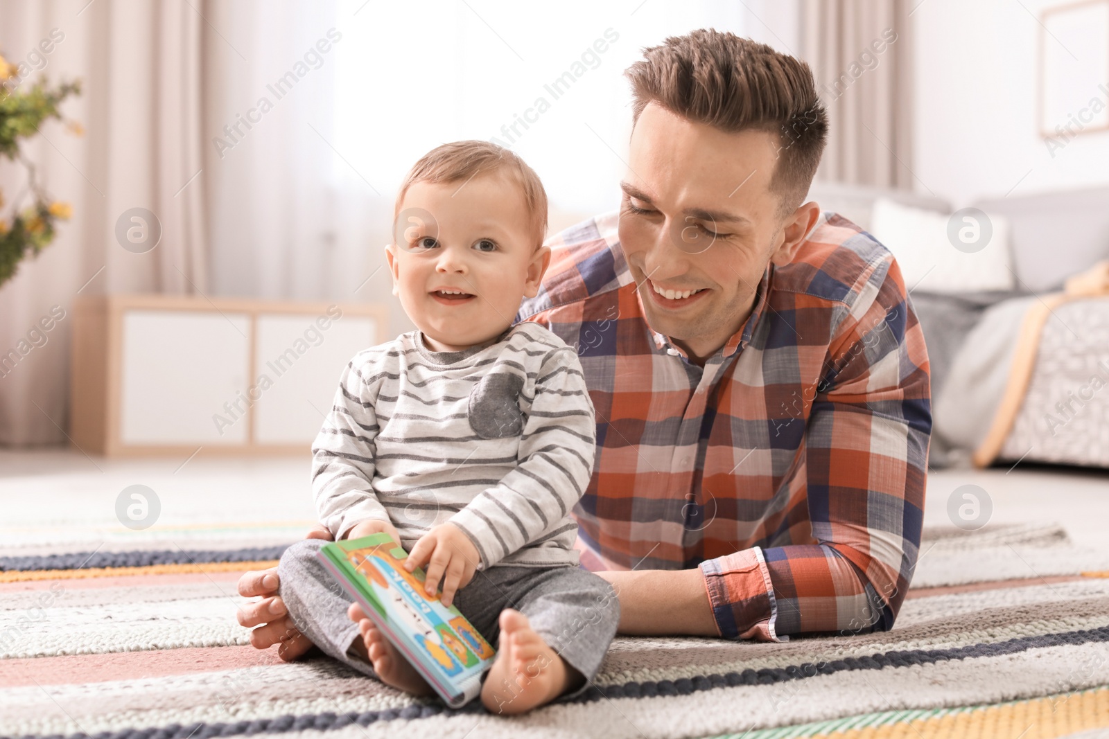 Photo of Young father with his cute little son at home