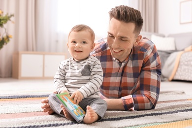 Young father with his cute little son at home