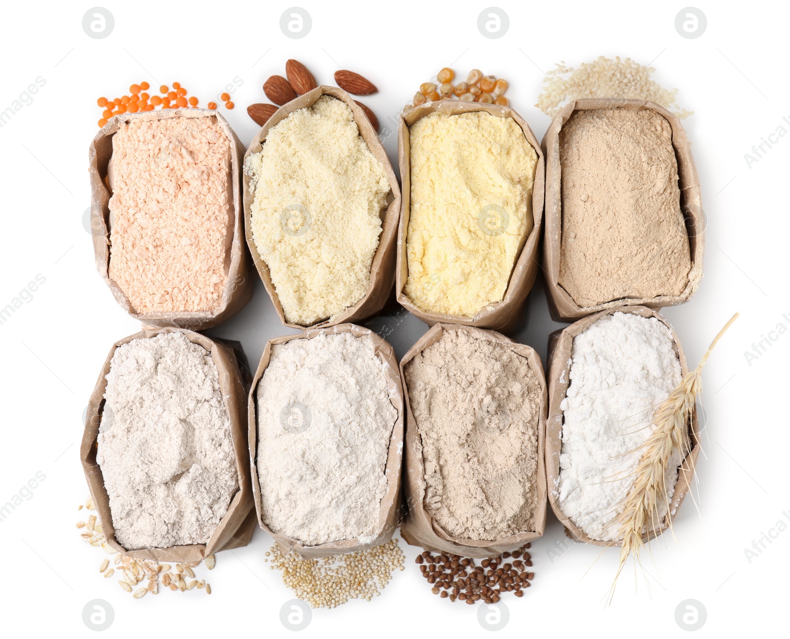 Photo of Paper bags with different types of flour on white background, top view