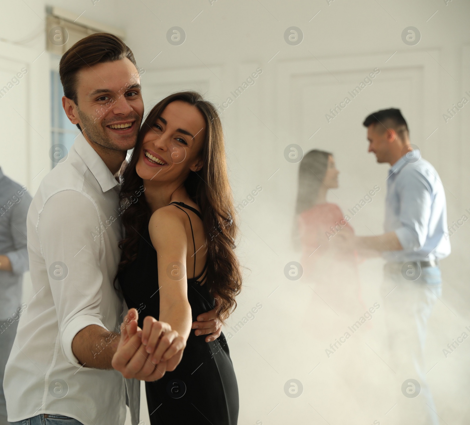 Photo of Lovely young couple dancing together at party