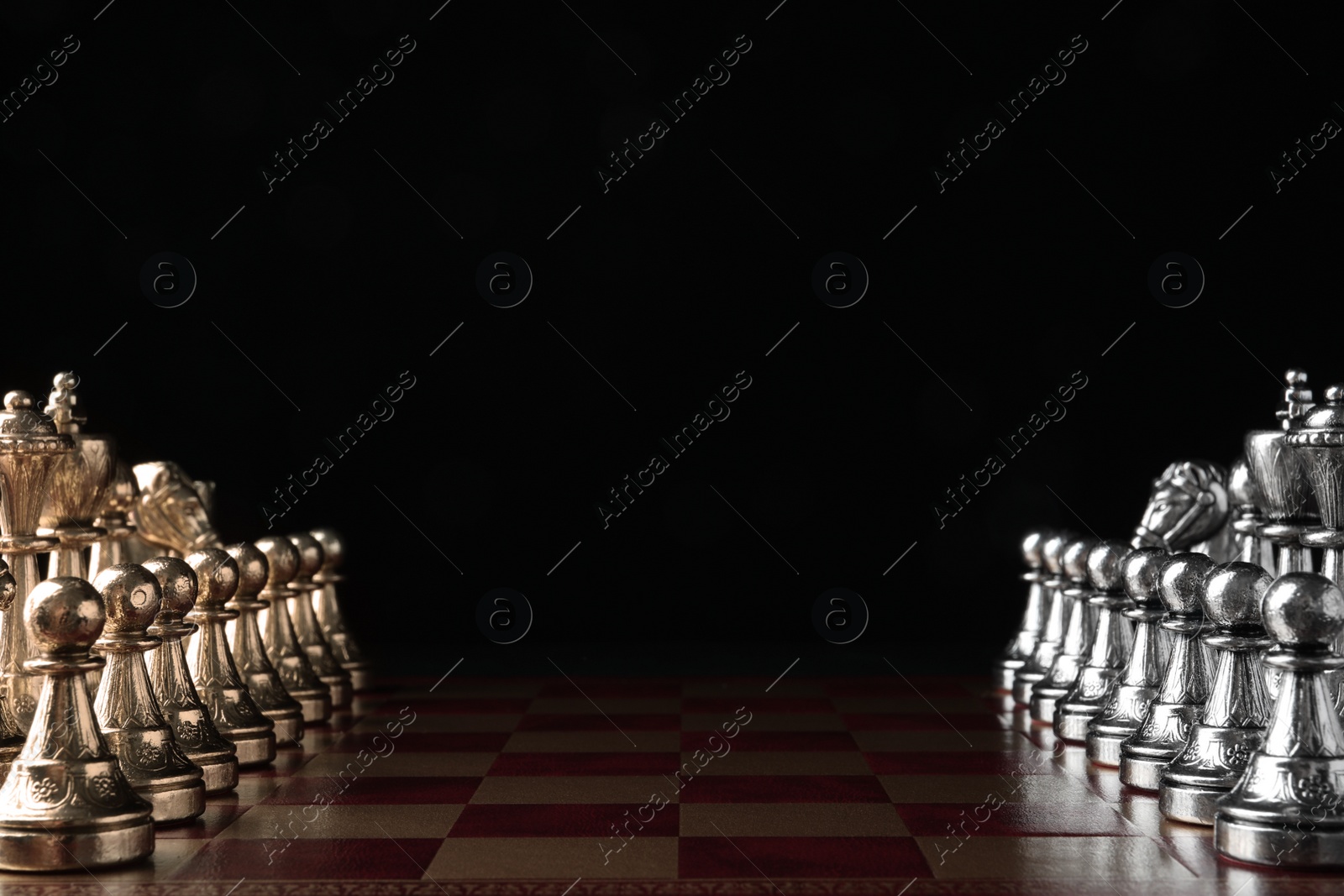 Photo of Chessboard with game pieces on black background. Space for text