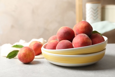 Photo of Plates with fresh sweet peaches on table