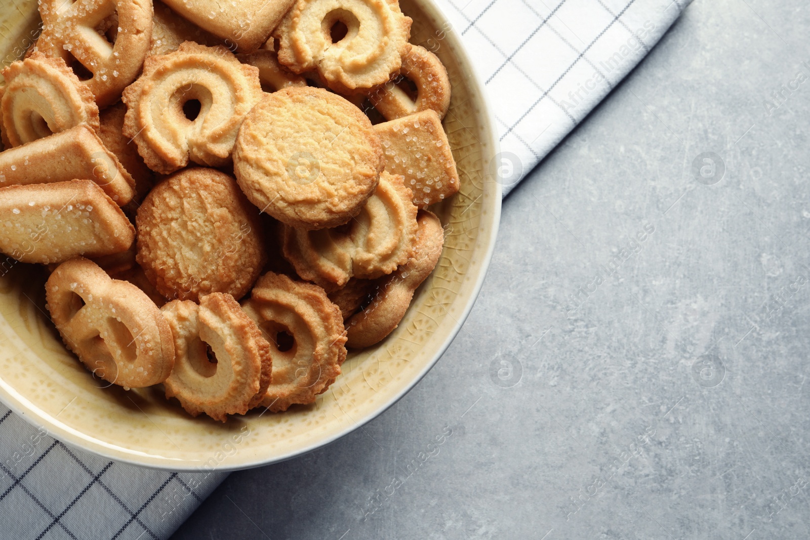 Photo of Bowl with Danish butter cookies on grey background, top view. Space for text