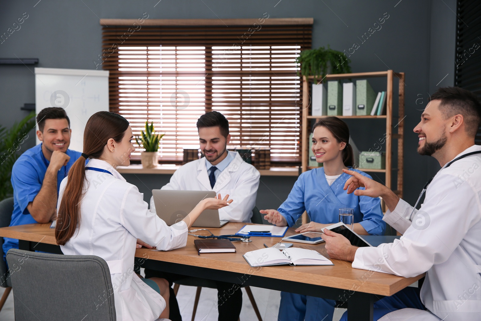 Photo of Team of professional doctors having meeting in office