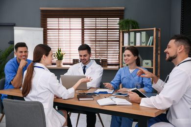 Photo of Team of professional doctors having meeting in office