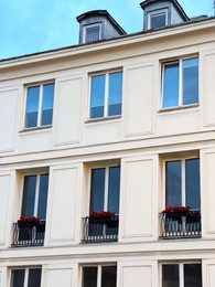 Photo of Modern building exterior with flowers on window railings