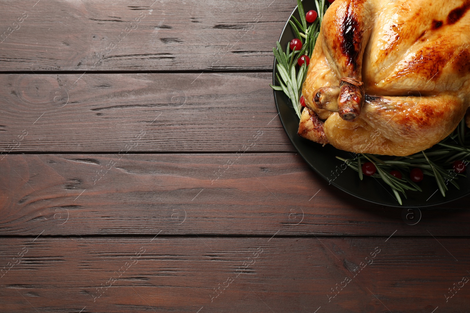 Photo of Delicious cooked turkey served on wooden table, top view with space for text. Thanksgiving Day celebration