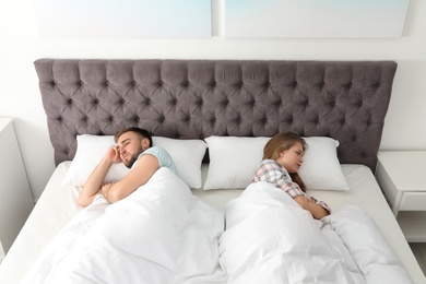 Photo of Young couple with relationship problems in bed at home