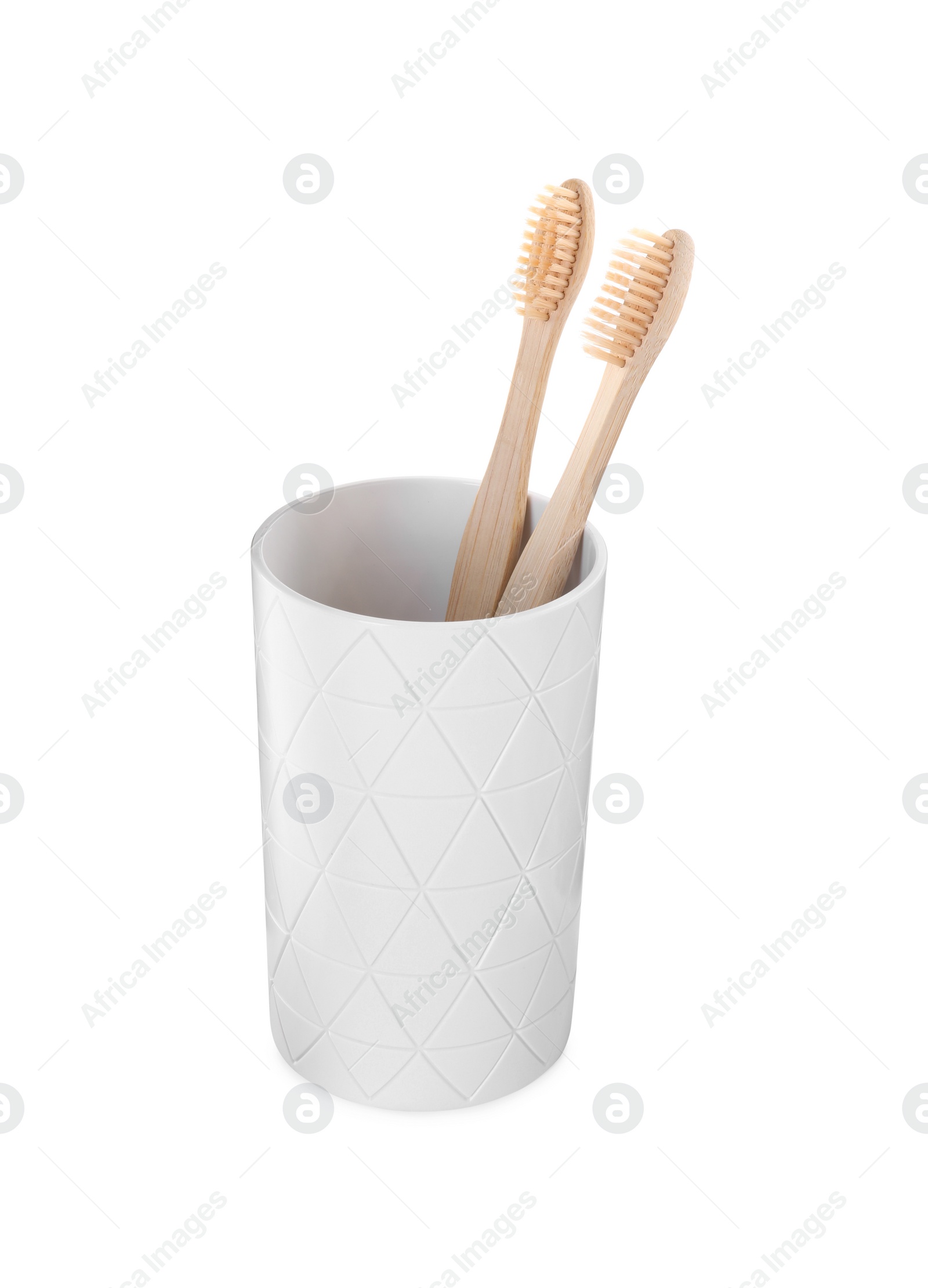 Photo of Bamboo toothbrushes in holder isolated on white
