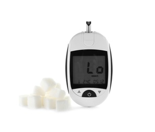 Photo of Digital glucometer and sugar cubes on white background. Diabetes concept