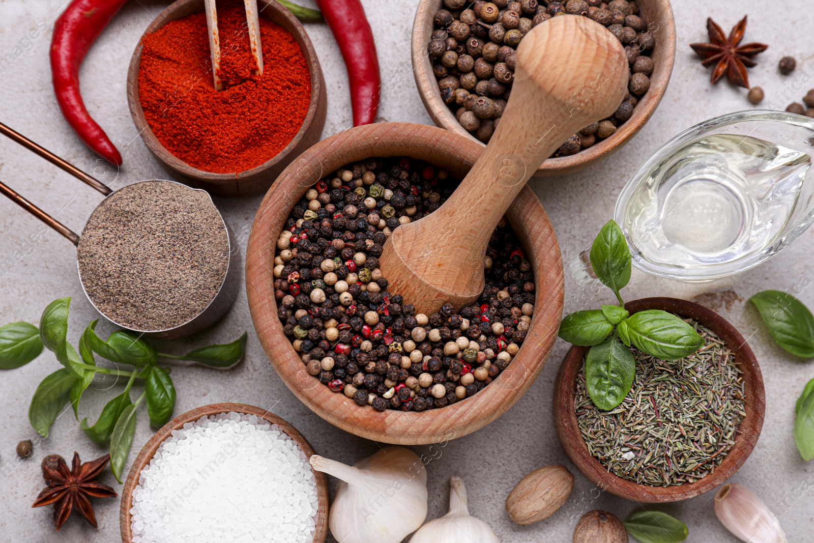 Photo of Mortar with different spices on light grey table, flat lay