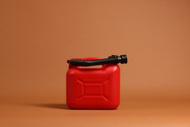 Photo of New red plastic canister on brown background