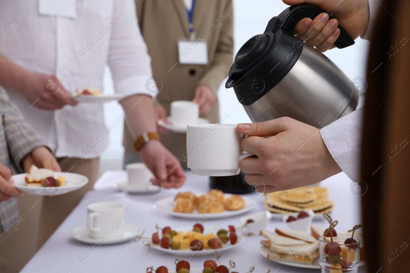 Photo of Waitress pouring hot drink during coffee break, closeup