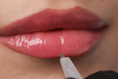 Young woman during procedure of permanent lip makeup in beauty salon, closeup