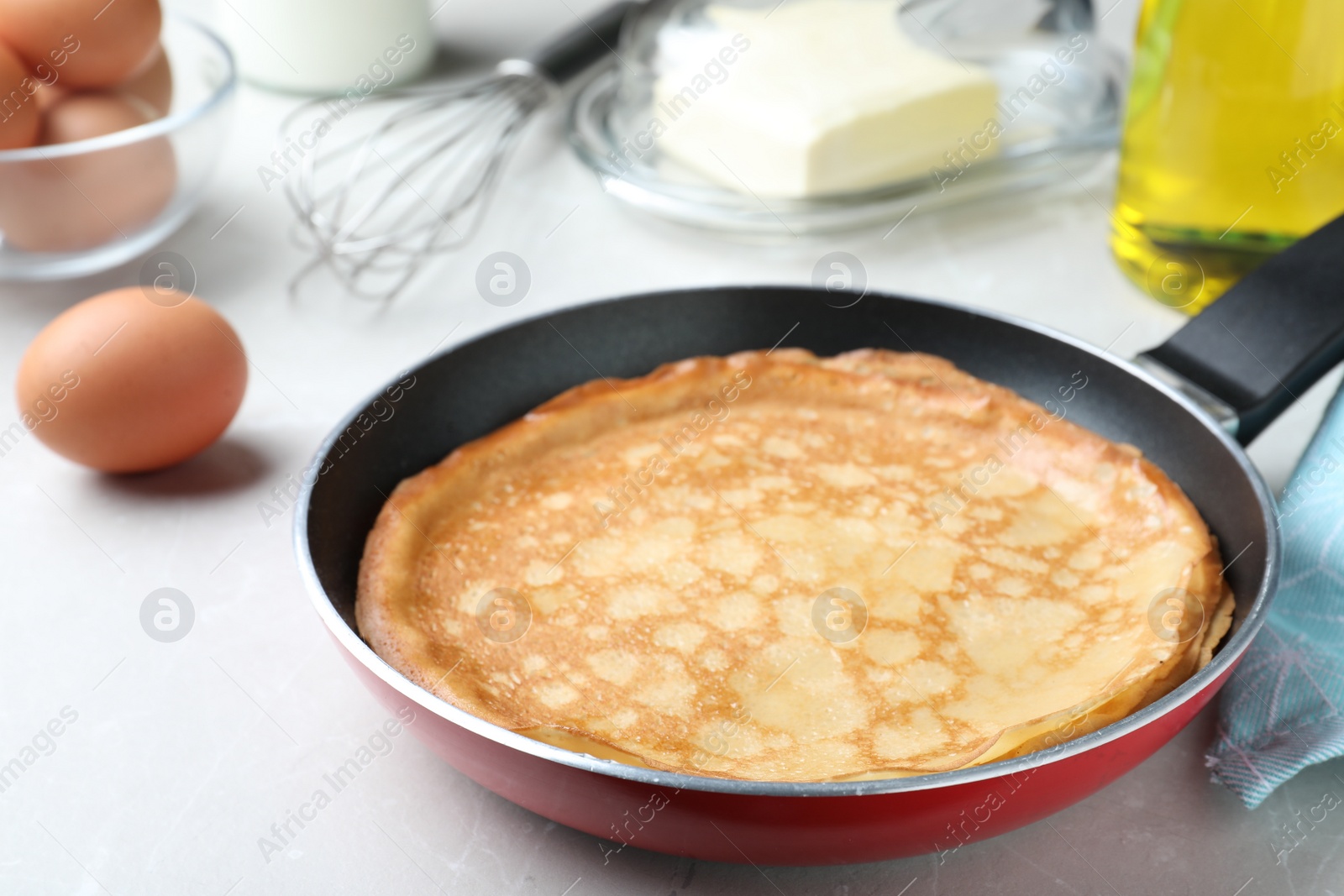 Photo of Delicious thin pancakes on grey marble table, closeup