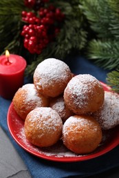 Delicious sweet buns, fir tree branches and burning candle on table, closeup