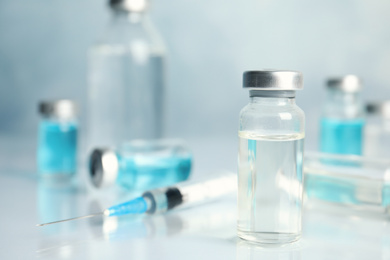 Vials and syringe on light table. Vaccination and immunization