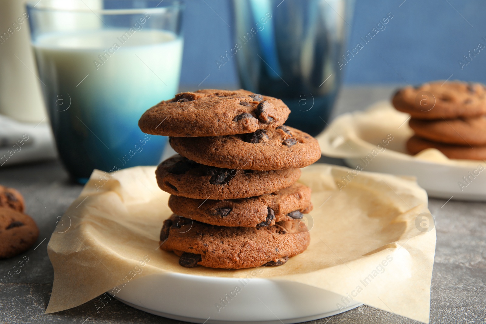 Photo of Plate with stack of tasty chocolate chip cookies on table