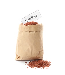 Paper bag with uncooked red rice and card on white background