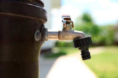 Photo of Metal water tap outdoors on sunny day