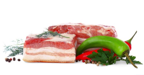 Photo of Pieces of pork fatback and different spices on white background