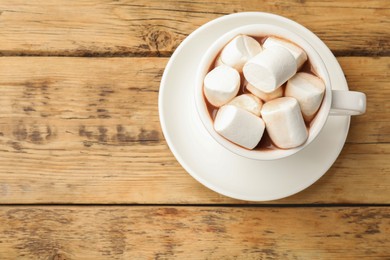 Tasty hot chocolate with marshmallows on wooden table, top view. Space for text