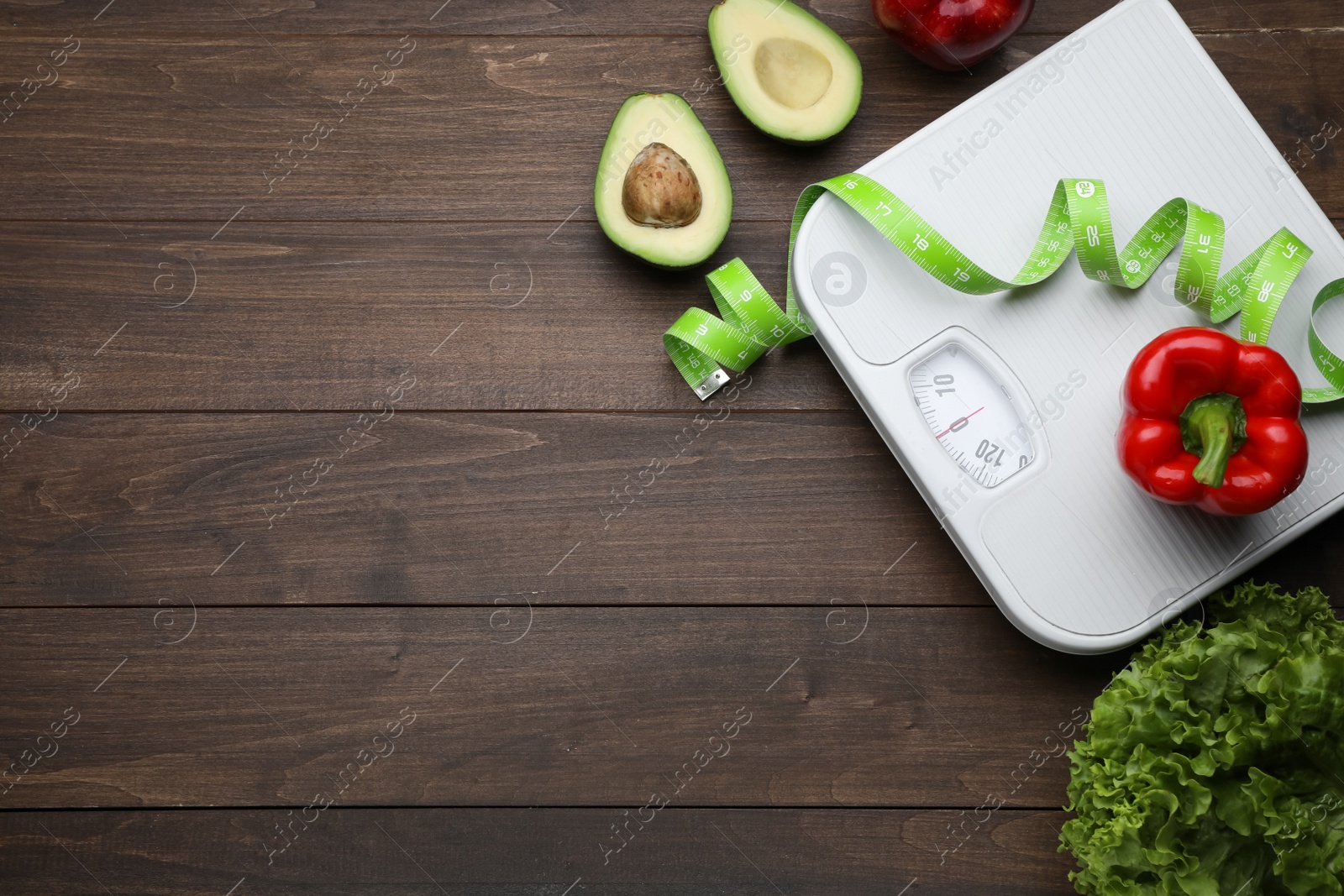 Photo of Flat lay composition with bathroom scale and measuring tape on wooden floor, space for text. Weight loss concept