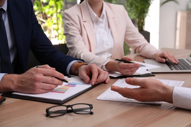 Photo of Business people working with documents at table in office, closeup. Investment analysis